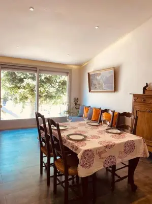 a dining room with a table and chairs at Bright airy family style 7 min walk to beach in Caldes d'Estrac