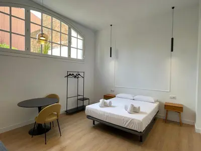 a bedroom with a bed and a table and a window at Hotelito Boutique Badalona Gran Villa in Badalona