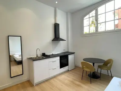 a kitchen with a sink and a table and a mirror at Hotelito Boutique Badalona Gran Villa in Badalona