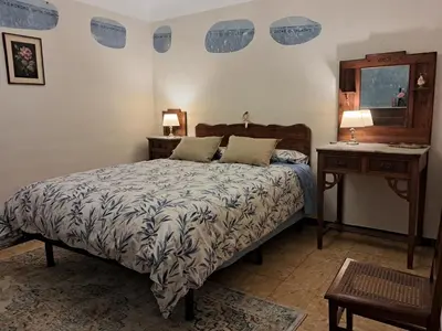 a bedroom with a bed and two tables and a mirror at Cal Fardassa in Gélida