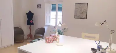 a room with a white counter and chairs and a table at Cal Fardassa in Gélida