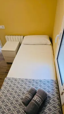 a bed in a small room with two pillows on it at Besos Apartment Barcelona in Sant Adria de Besos