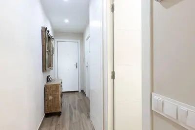a hallway with white walls and wood floors at Besos Apartment Barcelona in Sant Adria de Besos