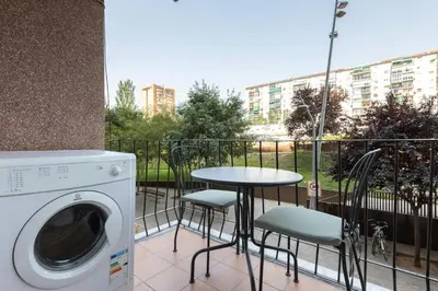a balcony with a table and chairs and a washing machine at Besos Apartment Barcelona in Sant Adria de Besos