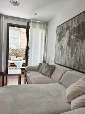a living room with a couch and a large painting at Reina apartment in Sitges in Sitges