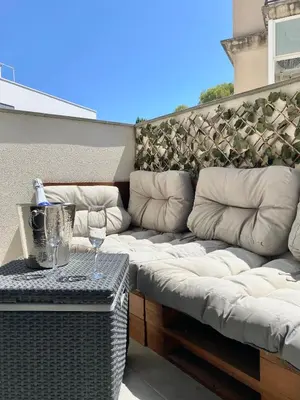 a couch sitting on a balcony with a glass of wine at Reina apartment in Sitges in Sitges