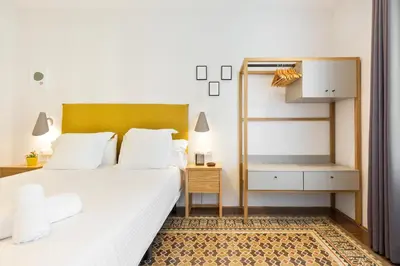 a bedroom with a large white bed and a desk at Bailen Apartments by Central in Barcelona