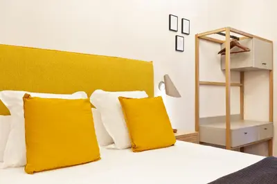 a bedroom with a bed with two yellow pillows at Bailen Apartments by Central in Barcelona
