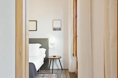 a bedroom with a white bed and a table at Bailen Apartments by Central in Barcelona