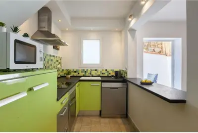 a kitchen with green and white counters and a window at La Casita de Caldetes in Caldes d'Estrac
