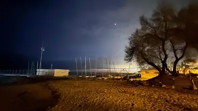 a tree sitting next to a building at night at La Casita de Caldetes in Caldes d'Estrac