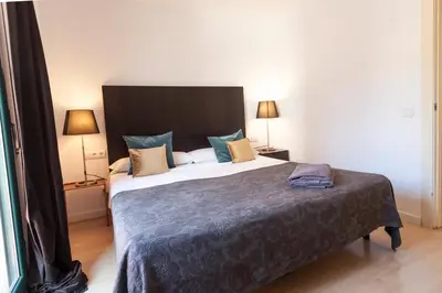 a bedroom with a large bed and two lamps at Plaza Catalunya City Center Apartments in Barcelona