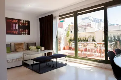 a living room with a couch and a large window at Plaza Catalunya City Center Apartments in Barcelona