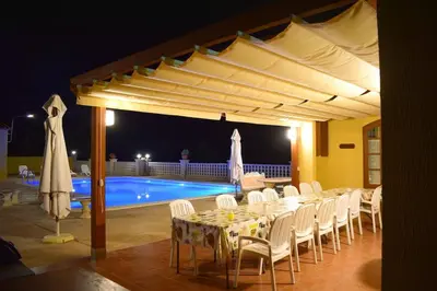 a dining area with a table and chairs and a pool at Cal Vimón in Las Masucas