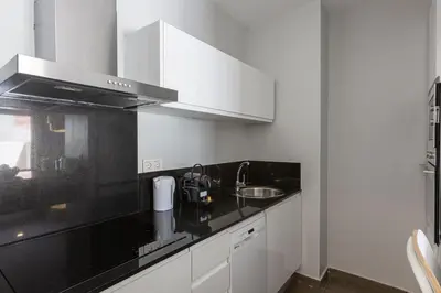 a kitchen with white cabinets and a black counter top at 4235 - AB Santa Coloma 3 B-I in Santa Coloma