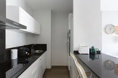 a kitchen with white cabinets and a black counter top at 4235 - AB Santa Coloma 3 B-I in Santa Coloma