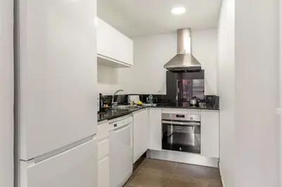 a kitchen with white cabinets and a stove top oven at 4237 - AB Santa Coloma III in Santa Coloma