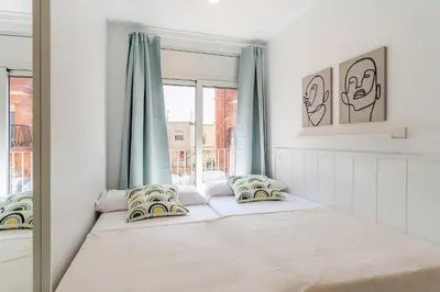 a white bedroom with a bed and a window at 4239 - AB Duplex Santa Coloma III in Santa Coloma