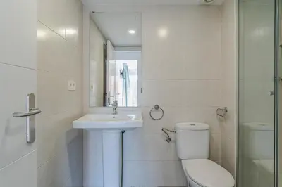 a white bathroom with a toilet and a sink at 4239 - AB Duplex Santa Coloma III in Santa Coloma