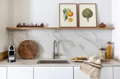 a kitchen counter with a sink and some framed pictures at Luxury Apt with King Beds & Central AC in Heart of BCN in Barcelona