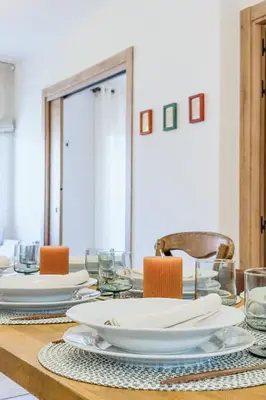 a dining room table with white plates and chairs at Apartamento exclusivo en Sant Antoni in Barcelona