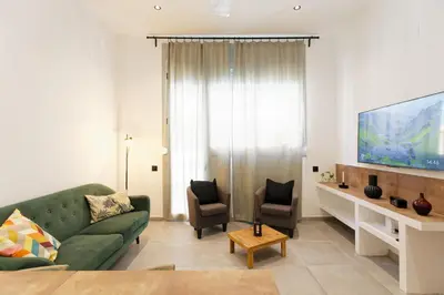 a living room with a green couch and a flat screen tv at Mediterranean Bliss in Sant Adria de Besos