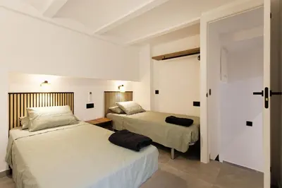 a bedroom with two beds and a door to a room at Mediterranean Bliss in Sant Adria de Besos