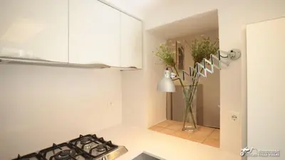 a vase filled with flowers on a floor in a room at Charming Casa in Sitges centre & minutes to beach in Sitges
