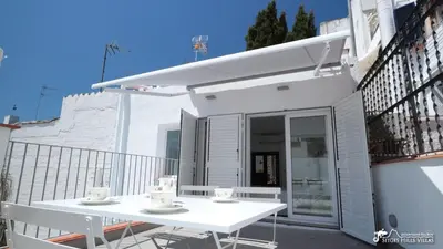 a white bedroom with a white bed with two pillows at Charming Casa in Sitges centre & minutes to beach in Sitges