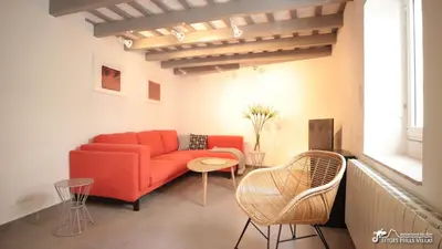 a living room with a red couch and a table at Charming Casa in Sitges centre & minutes to beach in Sitges