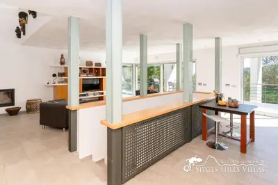 a living room with a glass table and a chair at Villa Lucere with private pool near Sitges in Olivella
