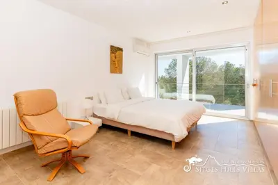 a living room with a wooden table and chairs at Villa Lucere with private pool near Sitges in Olivella