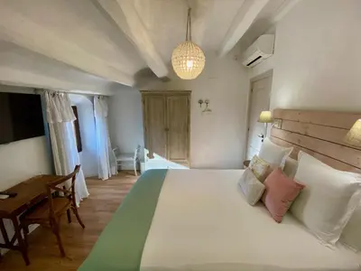 a bedroom with a large white bed and a desk at Bed & Breakfast Wine & Cooking Penedès in Pla del Panadés