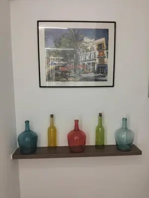 a group of vases sitting on a shelf under a picture at Vidanova 1 in Vilanova i la Geltrú
