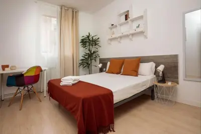 a bedroom with a bed with a table and a chair at Renovated Apartment in Vila de Gràcia in Barcelona