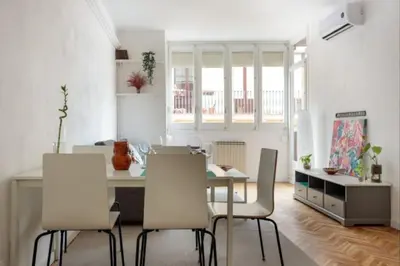 a dining room with a table and white chairs at Renovated Apartment in Vila de Gràcia in Barcelona
