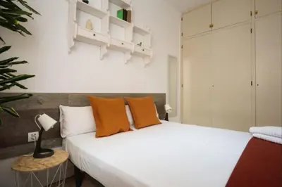 a bedroom with a large white bed with orange pillows at Renovated Apartment in Vila de Gràcia in Barcelona