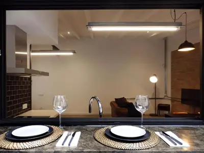 a kitchen with a table with two plates and wine glasses at Loft reformado in Cornellà de Llobregat