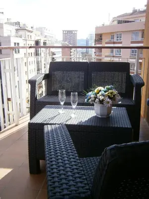 a table with two wine glasses and flowers on a balcony at Marbel 2 in Barcelona