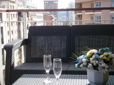 two wine glasses and a vase with flowers on a balcony at Marbel 2 in Barcelona