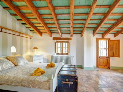 a bedroom with a large bed and a wooden ceiling at Masia Palou Alt by Hello Homes Sitges in Sitges