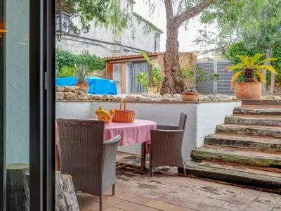 a table and chairs with a pink table and some stairs at Masia Palou Alt by Hello Homes Sitges in Sitges