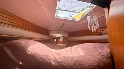 a bed in a small room with a window at Velero Draco in Sitges