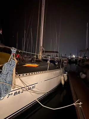 a white boat docked in a harbor at night at Velero Draco in Sitges