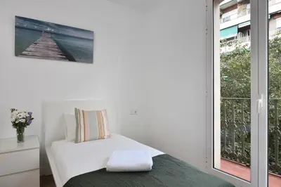 a bedroom with a bed and a large window at Encantador piso en el centro in Barcelona