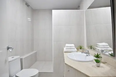 a white bathroom with a sink and a toilet at Encantador piso en el centro in Barcelona