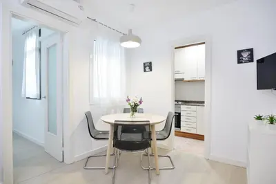 a kitchen and dining room with a table and chairs at Encantador piso en el centro in Barcelona