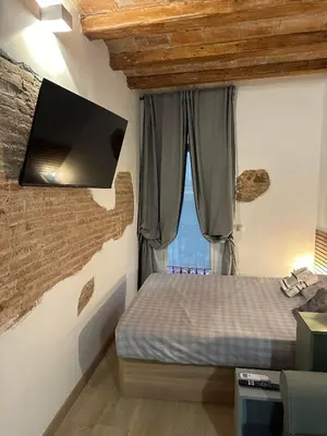 a bedroom with a bed and a tv on the wall at Stay Happy in Barcelona