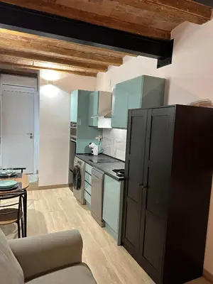 a kitchen with blue cabinets and a couch in a room at Stay Happy in Barcelona