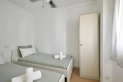 a small bedroom with two beds and a mirror at 17 Nice apartment next to El Molino in Barcelona